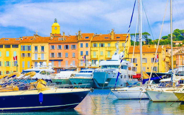 boats on the water in front of the yellow houses in the harbour at Saint Tropez