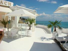 A pretty white terrace with a nautical feel surrounds this beach-side luxury holiday villa in Garoupe.
