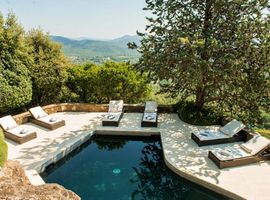6 sunloungers positioned around a shaded private terrace and a Balinese-stype swimming pool nestled amongst mature trees with a view to the Gulf of St Tropez.