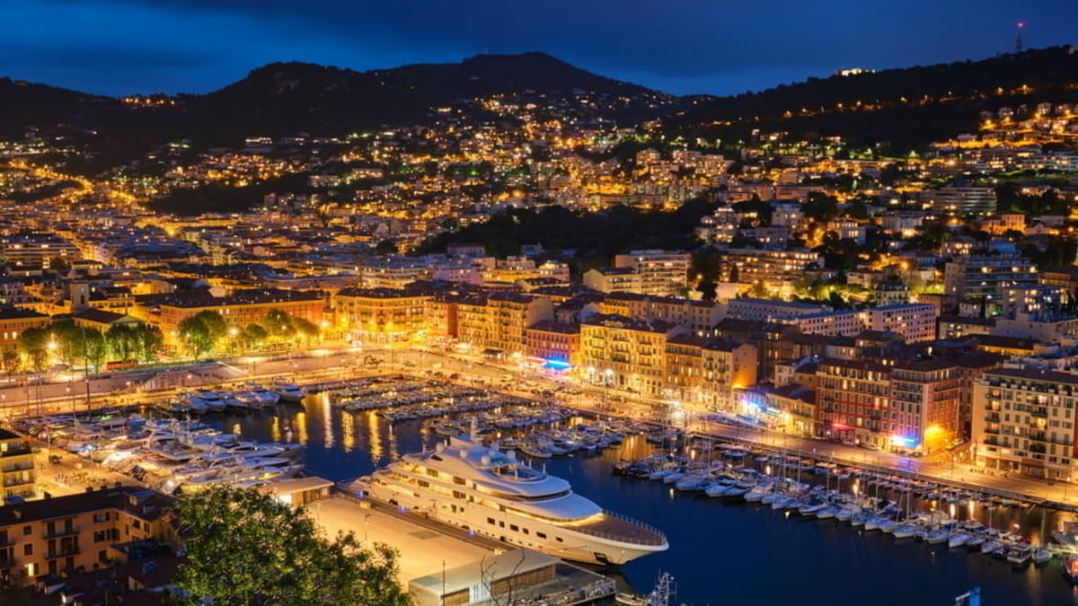 Aerial view of Monaco by night with ships in harbour
