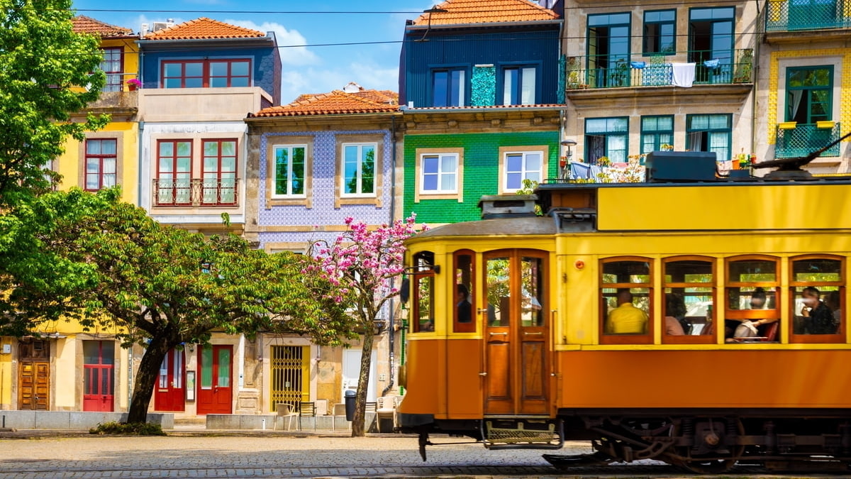 Tram in Lisbon, Portugal, going through it's  beautiful traditional pastel coloured houses.